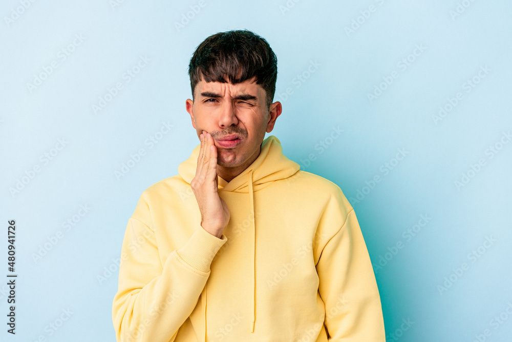 Young mixed race man isolated on blue background having a strong teeth pain, molar ache.