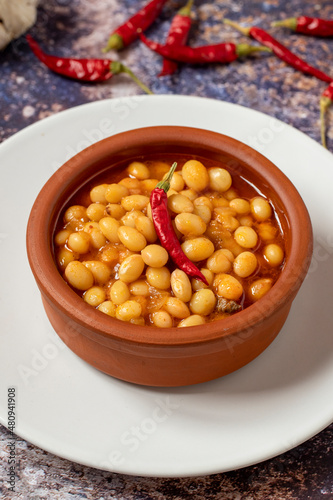 Hot turkish bean stew on wooden background. Ispir beans cooked in a casserole - Kuru Fasulye