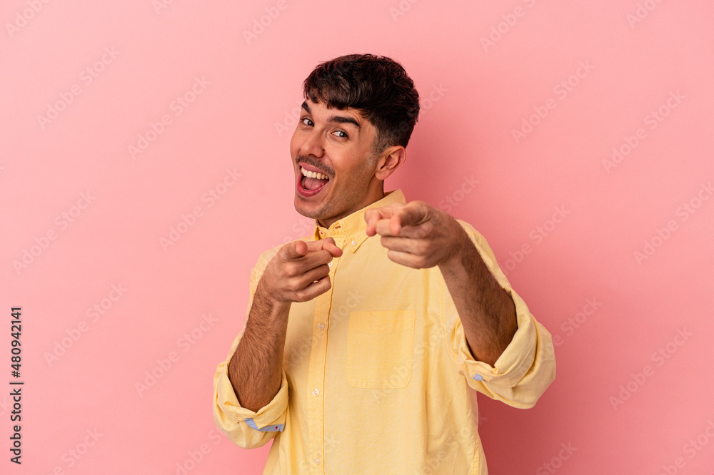 Young mixed race man isolated on pink background cheerful smiles pointing to front. Young mixed race man isolated on pink background cheerful smiles pointing to front.