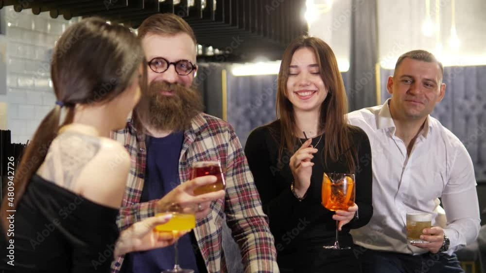 A diverse group of friends celebrate,talk and drink alcoholic cocktails together in a stylish nightclub.Beautiful young people are having fun in a stylish bar restaurant.Concept of rest and celebratio A diverse group of friends celebrate,talk and drink alcoholic cocktails together in a stylish nightclub.Beautiful young people are having fun in a stylish bar restaurant.Concept of rest and celebratio