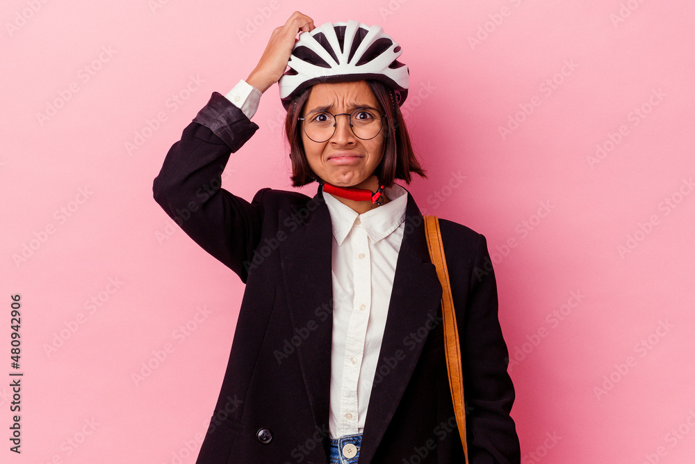 Young business mixed race woman wearing a bike helmet isolated on pink background being shocked, she has remembered important meeting. Young business mixed race woman wearing a bike helmet isolated on pink background being shocked, she has remembered important meeting.