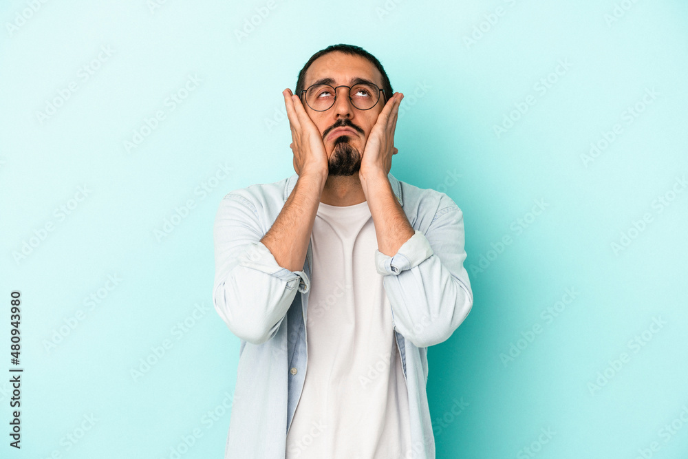 Young caucasian man isolated on blue background whining and crying disconsolately. Young caucasian man isolated on blue background whining and crying disconsolately.