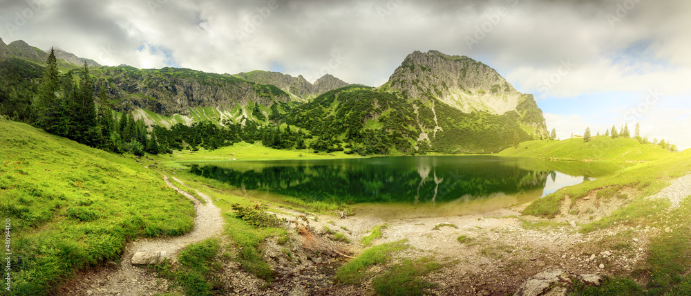 Obraz premium Panoramic scenery around a mountain lake with dramatic sunlight 