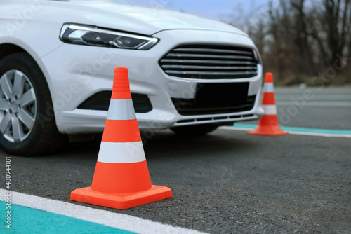Modern car at test track, focus on traffic cone. Driving school