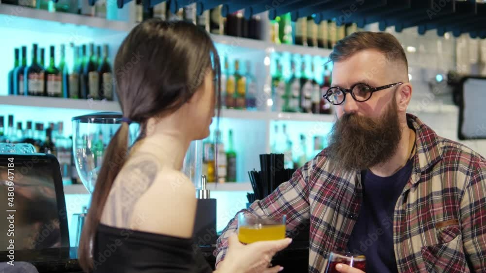 A couple enjoys a date, talking and drinking alcoholic cocktails together in a stylish nightclub.Beautiful young people are having fun in a stylish bar,restaurant.The concept of rest and love. Smiling A couple enjoys a date, talking and drinking alcoholic cocktails together in a stylish nightclub.Beautiful young people are having fun in a stylish bar,restaurant.The concept of rest and love. Smiling