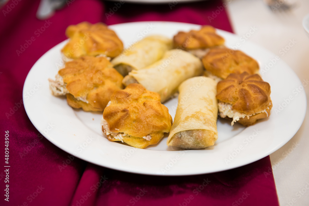 Pastries are different on the festive table. Culinary baked appetizer on dishes.