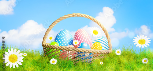 easter eggs in basket and grass field on sky background.