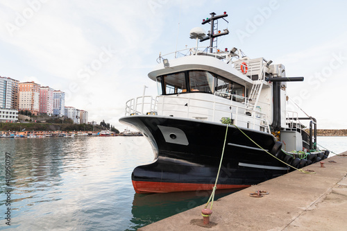 Industrial fishing boat is moored in small fishing harbor