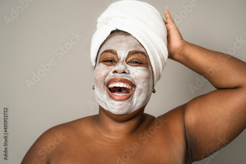 Happy curvy African woman having skin care spa day - People self care lifestyle concept photo