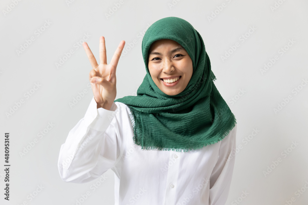 Young Muslim woman pointing up three fingers for raising 3 points concept Young Muslim woman pointing up three fingers for raising 3 points concept