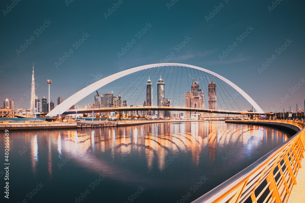 Fototapeta premium DUBAI, UAE - FEBRUARY 2018: Colorful sunset over Dubai Downtown skyscrapers and the newly built Tolerance bridge as viewed from the Dubai water canal.