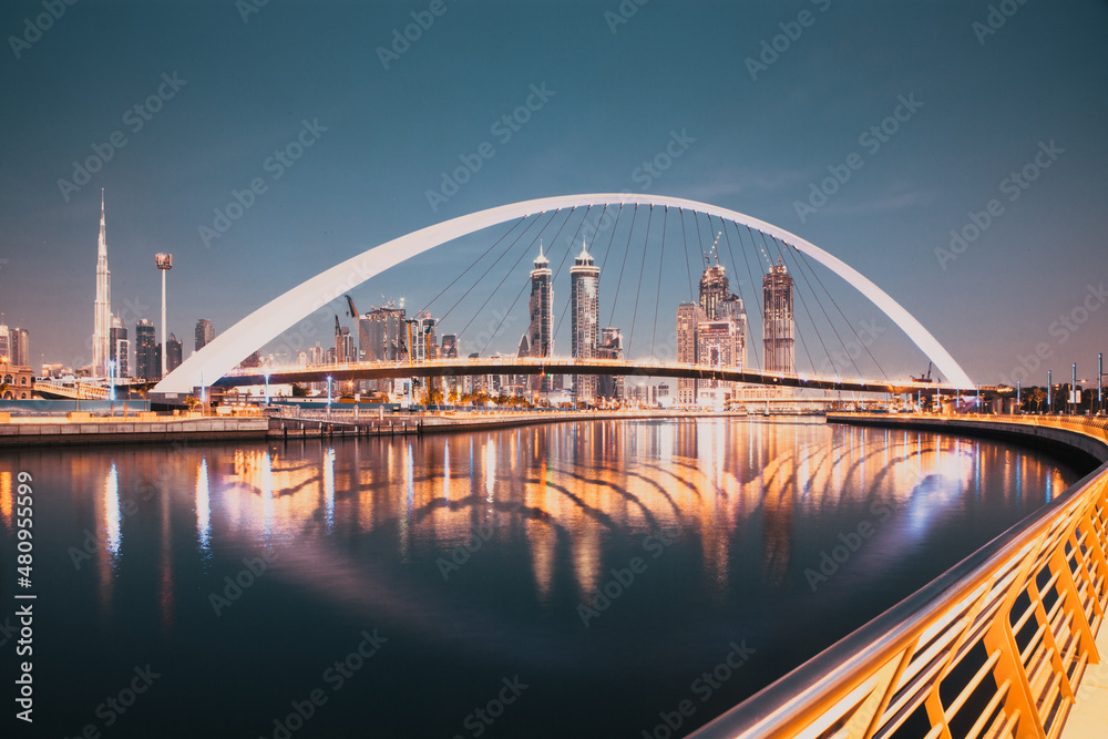 Obraz premium DUBAI, UAE - FEBRUARY 2018: Colorful sunset over Dubai Downtown skyscrapers and the newly built Tolerance bridge as viewed from the Dubai water canal.