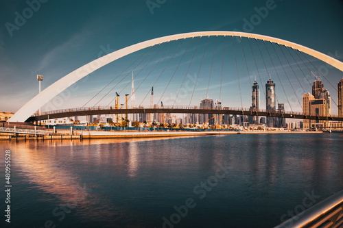 DUBAI, UAE - FEBRUARY 2018: Colorful sunset over Dubai Downtown skyscrapers and the newly built Tolerance bridge as viewed from the Dubai water canal.