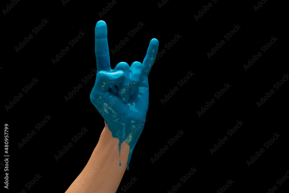 Male hand painted blue gesturing isolated on dark studio background. Concept of human relation, symbolism, culture and history Male hand painted blue gesturing isolated on dark studio background. Concept of human relation, symbolism, culture and history