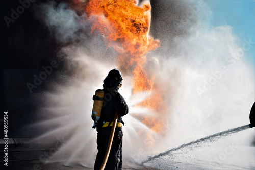 Bombero atacando a un fuego con un chorro de agua en forma de estrella photo