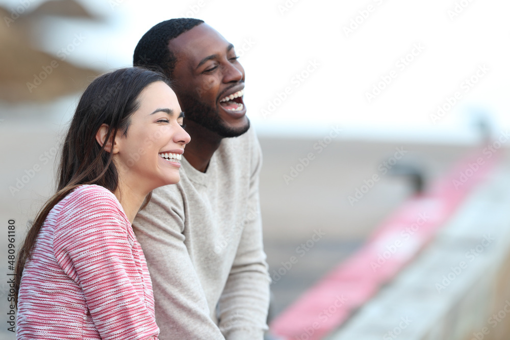 Interracial couple laughing dating in a pier