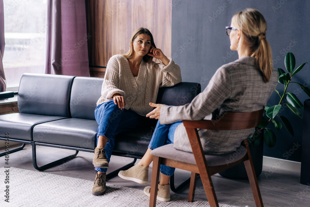 A young woman in a consultation with a professional psychologist listens to advice on improving behavior in life. The modern millennial woman is developing mindfulness and psychological health. - obrazy, fototapety, plakaty 