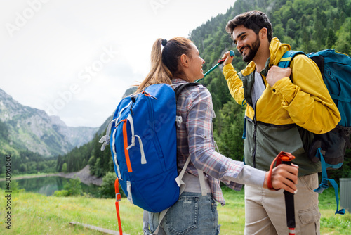 Group of smiling friends hiking with backpacks outdoors. Travel, tourism, hike and people concept.