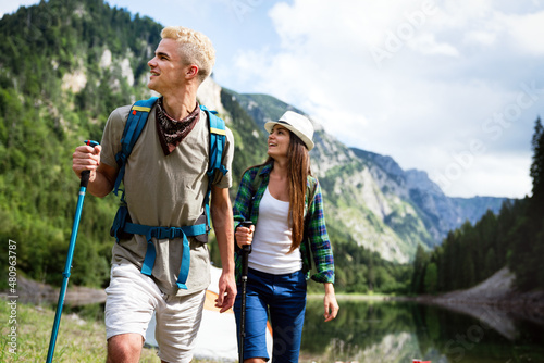 Happy couple smiling outdoors on hiking trip. Young couple enjoying nature.