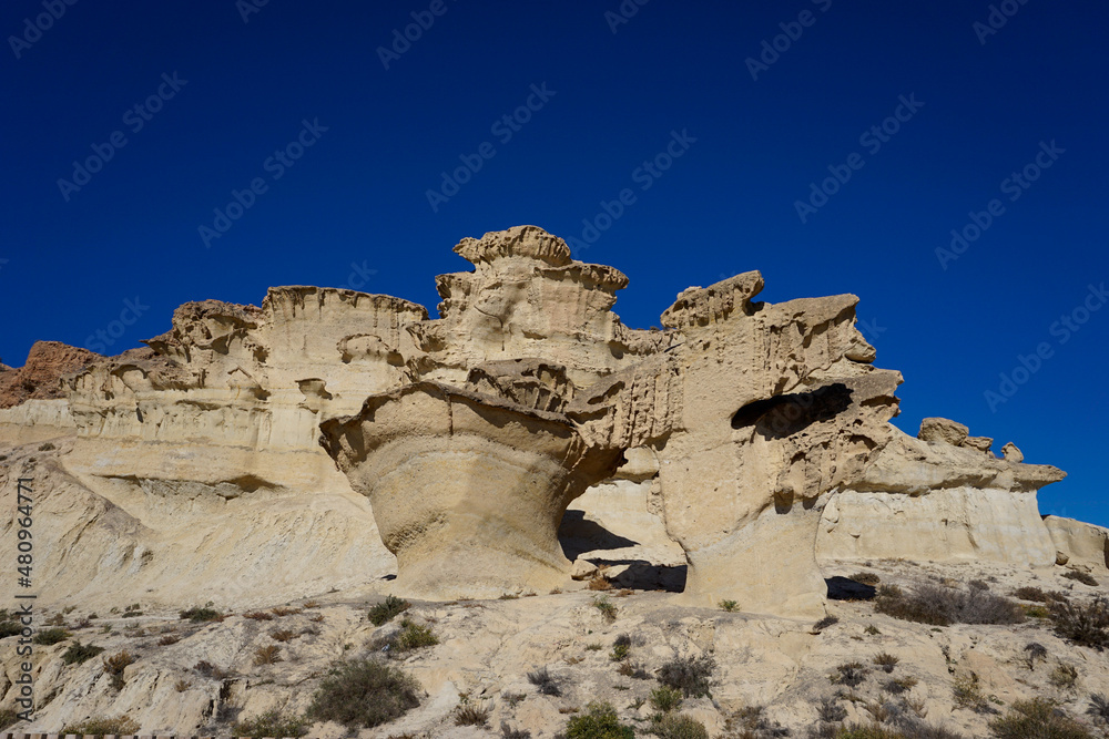 view of the famous sandstone erosions and hoodoos in Bolnuevo under a clear blue sky