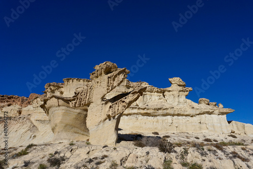 view of the famous sandstone erosions and hoodoos in Bolnuevo under a clear blue sky