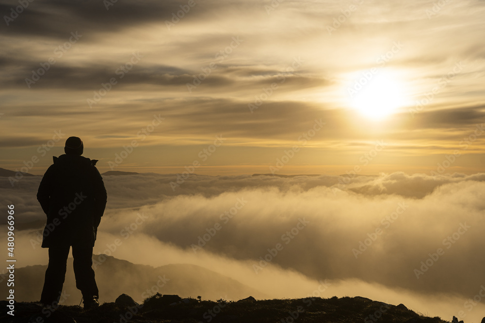 A man overlooking a beautiful cloud inversion sunrise in the UK countryside