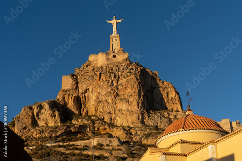 view of the statue of Christ in Murcia in golden evening light undeer a blue sky photo