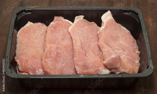 sliced raw pork meat with parsley and peppercorn isolated on white background