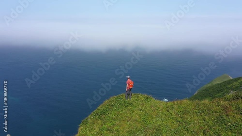 Traveler Standing on Edge of Shikotan Island and Looking on Pacific Ocean, Lesser Kuril Chain, Russia. Drone Shot. photo