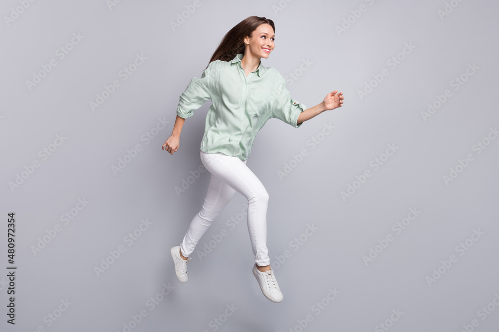 Fototapeta premium Full body profile photo of impressed brunette lady run wear blouse trousers sneakers isolated on grey color background