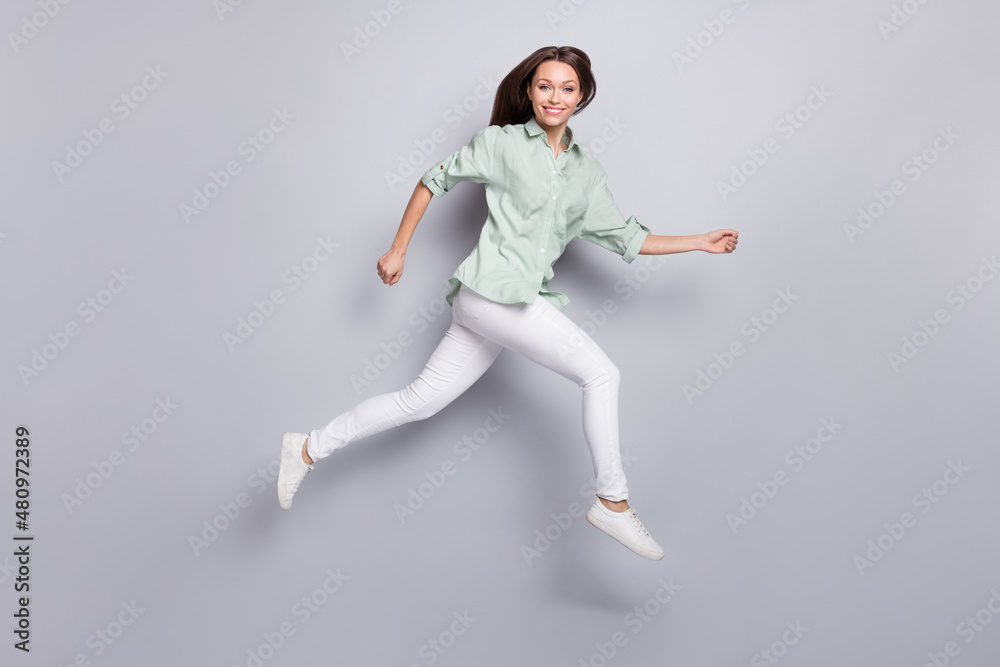 Full size profile photo of funny brunette lady run wear blouse trousers footwear isolated on grey color background