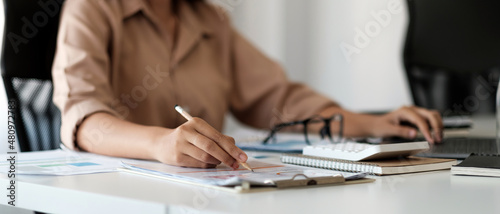 Close up business woman using calculator and working to calculate about finance accounting at coffeeshop outdor. finance accounting concept