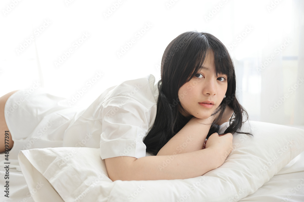 Beautiful young woman waking up in the morning at white bedroom Beautiful young woman waking up in the morning at white bedroom