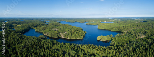 ..Bird's eye view of a lake and spruce forest. Aerial, drone nature photography taken from above in Finland in summer. © raland
