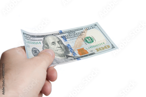A hand holding a bill hundred dollars. The concept of payment for services. Isolated.