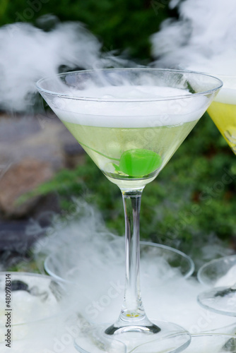 Outdoor cocktail party. Party at the pier. Pyramid of martini glasses at a party. Steaming cryo-cocktails.
