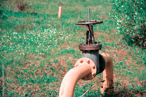 valve on the gas pipeline on a green meadow