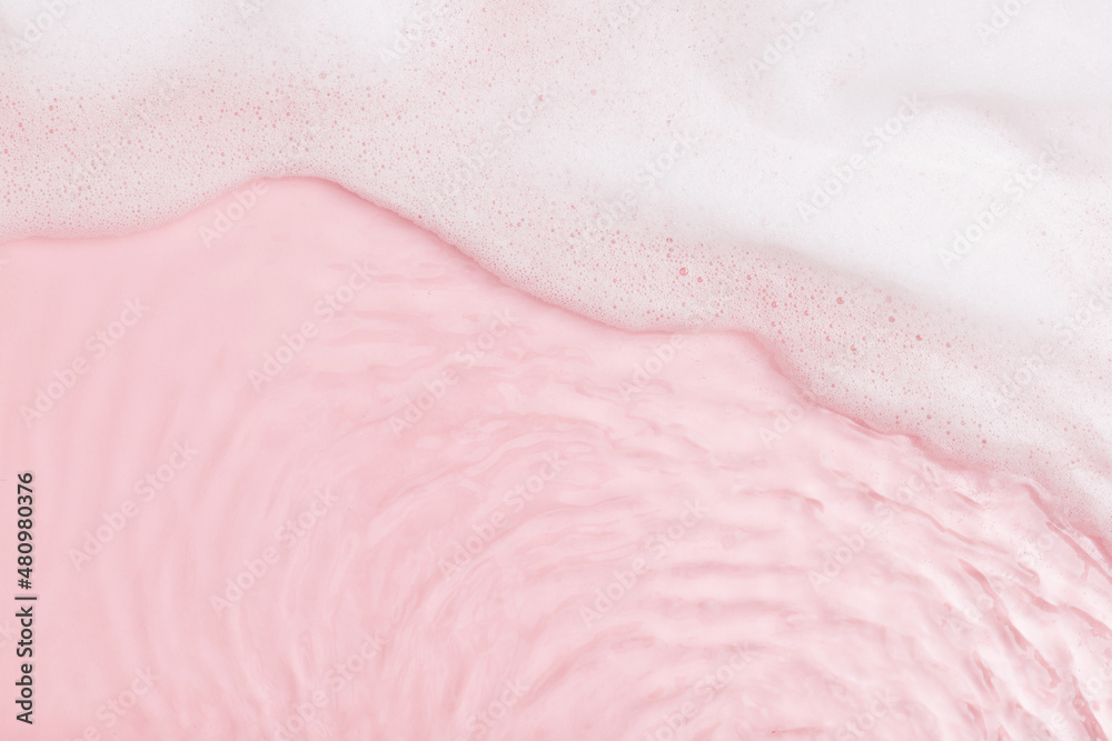 Fototapeta premium Top view of pink transparent clear calm water surface. Texture with splashes, foam and bubbles. Trendy abstract spring summer nature background for product. Flat lay cosmetic mockup
