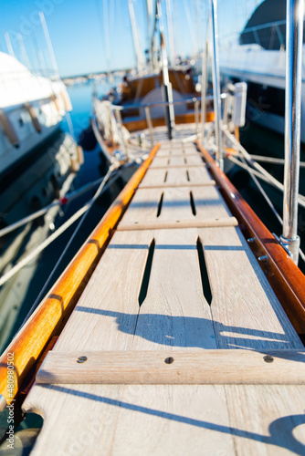 Perspective of a wooden gangway in the harbor of Varazze, Liguria, Italy. Blurred yacths on the background. Selective focus.