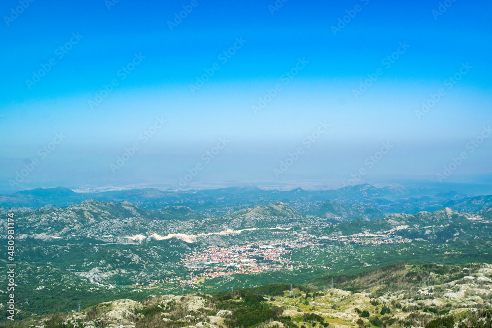 Cetinje city top landscape from viewpoint  Njegos mausoleum. Lovcen National Park. Montenegro. Summer blue montanian view.