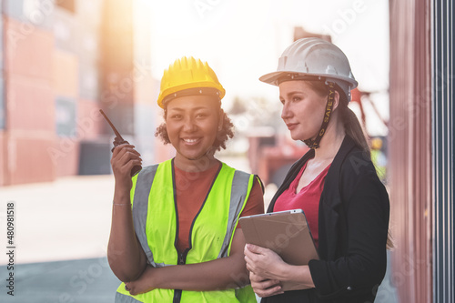 Worker teamwork logistics checking containers number befor loading shipment by large cargo ship transportation