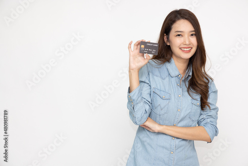 Young beautiful Asian woman smiling, showing, presenting credit card for making payment or paying online business isolated on white background