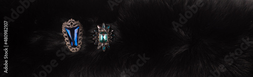Foto jewelry brooches on a black fur background