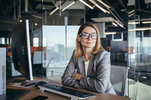 Portrait of a sensible and fair successful woman, businesswoman working in a modern office, at the computer, confident and focused
