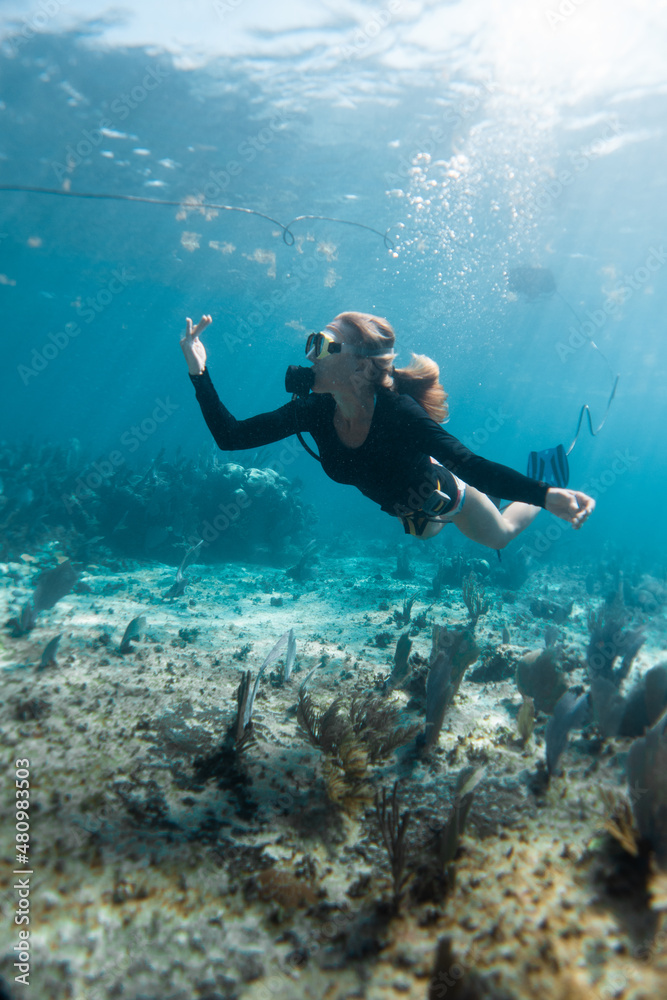 one young girl doing snuba in a reef coral