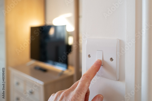 Canvas Print Shallow focus of a home owner switching off a bedroom light after waking up in late morning