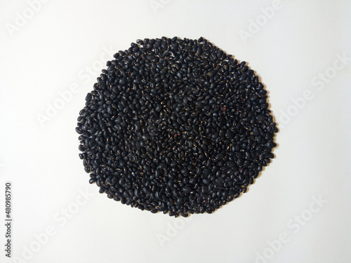 Seeds black beans (vigna mungo) isolated on white paper texture. photo