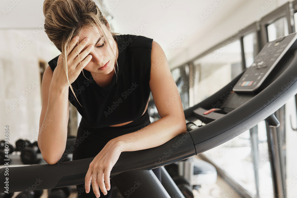 Fototapeta premium Exhausted woman after her fitness workout in the gym