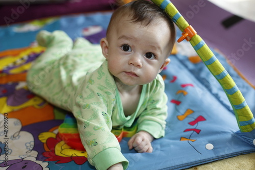 Un bébé est couché sur son tapis de jeu