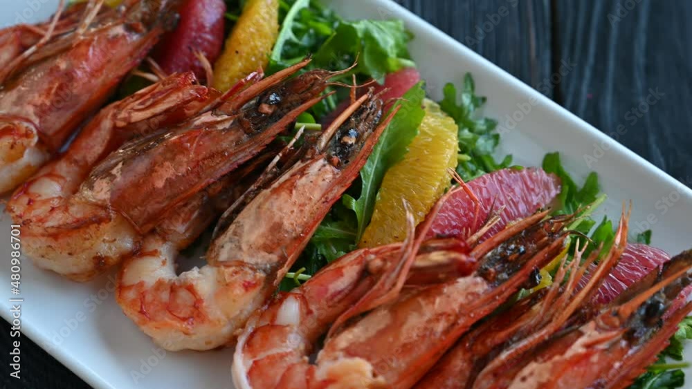 Grilled tiger prawns or shrimps with orange grapefruit and greens on a plate Grilled tiger prawns or shrimps with orange grapefruit and greens on a plate